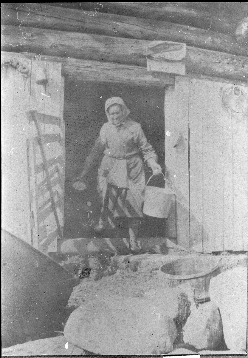 Kvinne med bøtter i døråpning: Olga Grønhovd (f. Flågan). Seter, muligens til Øvre Grønhovd.
Oppgitt å være fotografert rundt 1915, men ettersom Olga blei gift til Grønhovd 1923, er 1925 like sannsynlig.