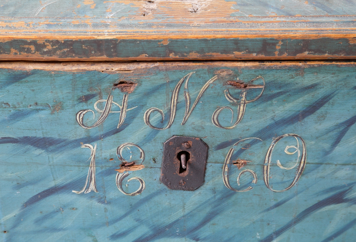 En blåmålad (marmorerad) förvaringskista med kupigt lock. Kistan har smidda beslag och handtag i järn. På framsidan märkt i vitt: "ANS, 1860".
Kistan har ett invändigt sidofack med lock.