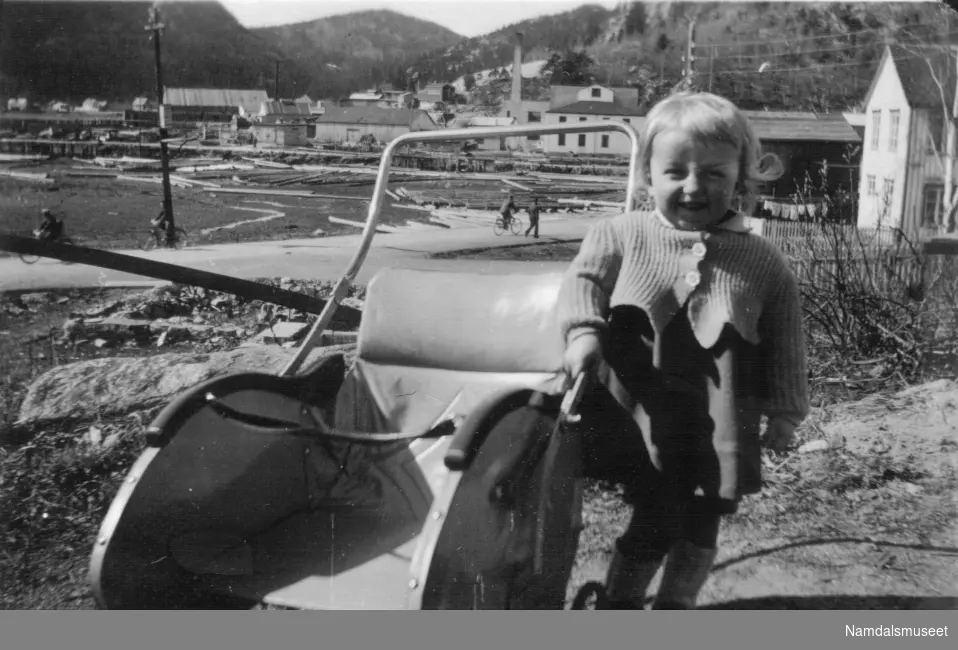 Et barn står ved en barnevogn