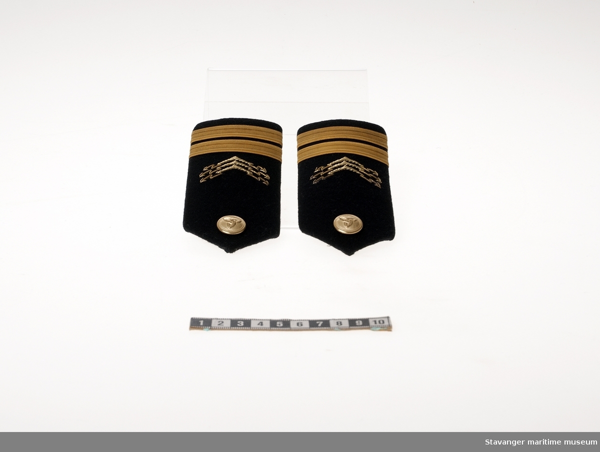 Distinksjon/epålett for sjefelektrikers uniform i mørkeblå ull dekorert med gulltråd og en gullknapp. En av et par.