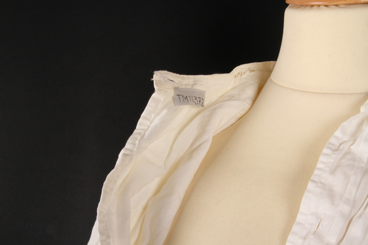 Sydd i hvitt, innfelt bryststykke i et annet stoff. I skjortekragen står Lund, stemplet inni et erme 39.