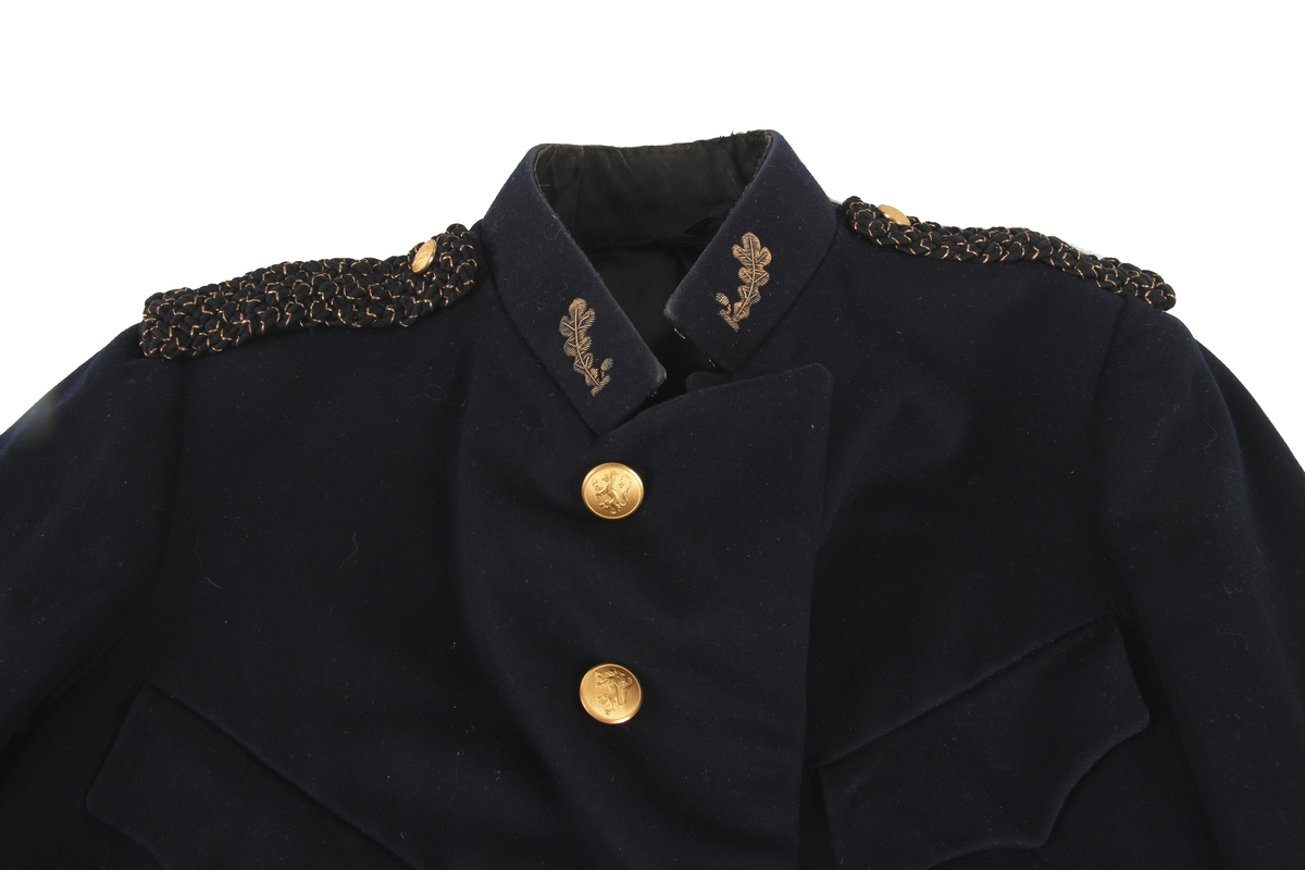 Herrejakke tilhørende en politiuniform. Hører sammen med en uniformsbukse.

Jakken er dekorert med skulderklaffer og messingknapper.