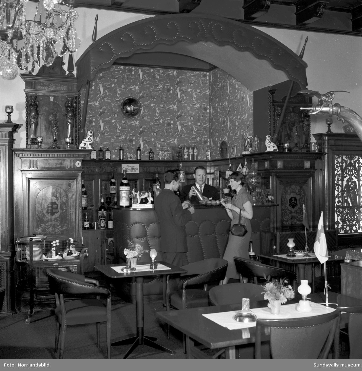 Barmästaren serverar en man och en kvinna i baren på Knaust.
