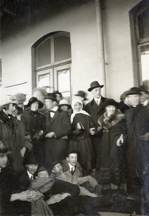 Ett sällskap med unga män och kvinnor utanför en järnvägsstation. Text under fotot: " - Falun, i väntan - på tåget - ". 
Överst rubrik: "- STUDIERESAN -".