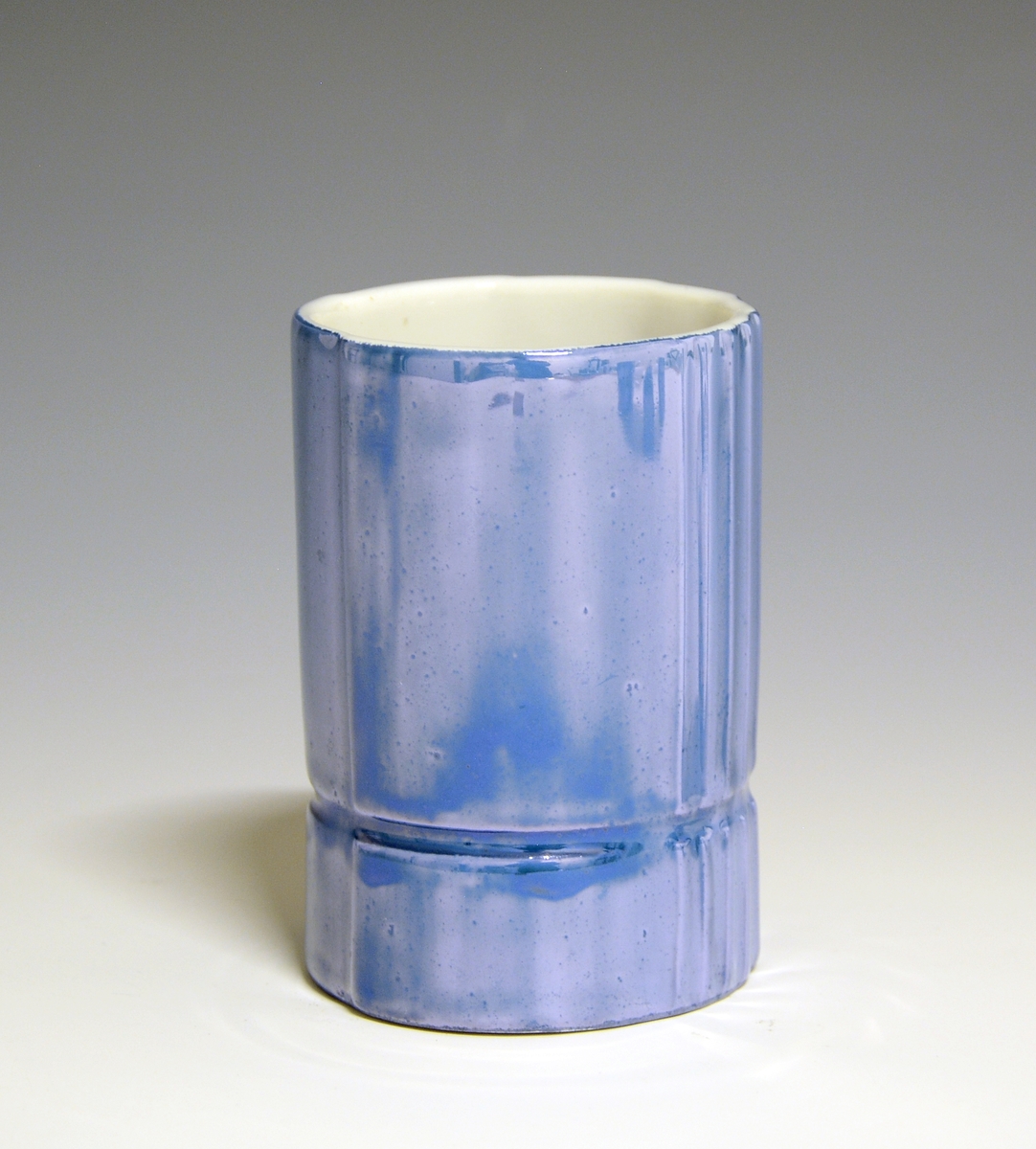 Vase og telysholder av porselen. Fungerer som lysestake den ene veien og vase den andre veien. Sylinderformet med en inntrapping i overgangen mellom vase og telysholder. Hvit glasur. Dekorert med blåfarget heldekkende dekor. 
Design: Grete Rønning.