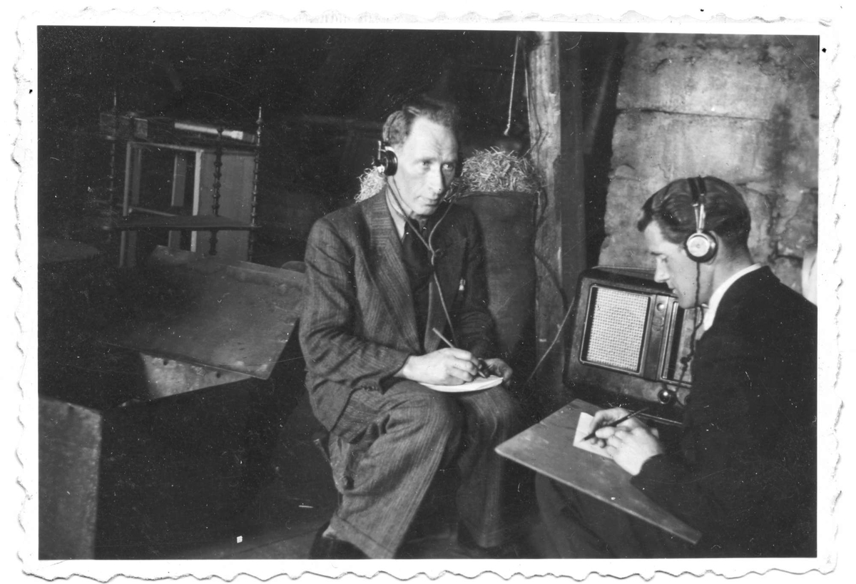 Olaf Angell og Kåre Andreassen tar notater mens de hører på radio.