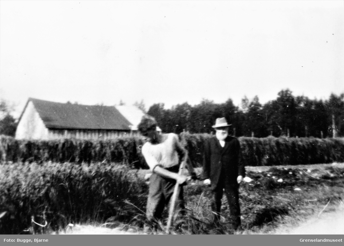 Slåttarbeid ved Øvre Storskog. Mannen til høyre er Martin Storskog.