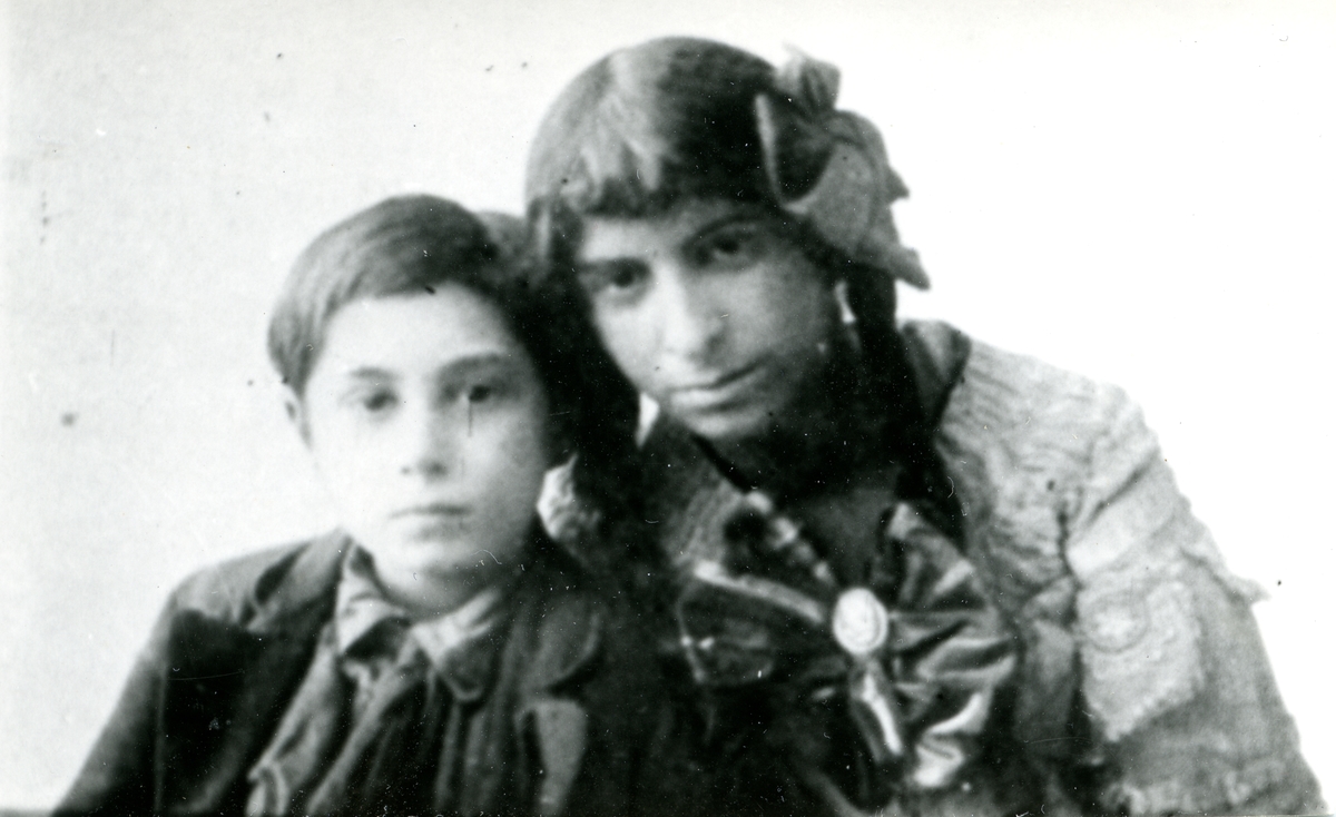 En pojke och en kvinna tittar in i kameran. Bilden är troligen tagen under tidigt 1900-tal, men bildens ursprung är okänt.
