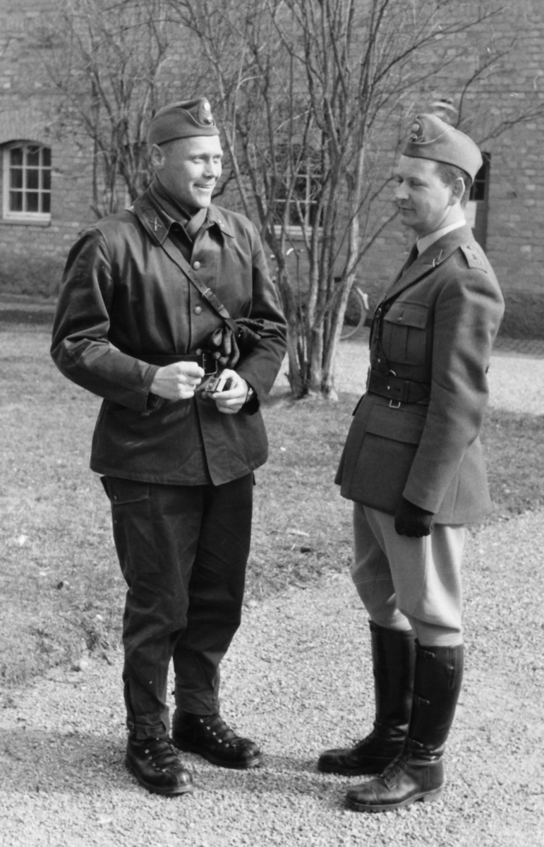 Bataljonsgatan, tidigt 60-tal

Löjtnanterna Arne Lindblom och Sten "Sten-Kalle" Karlsson.

Till den helt nya fältuniformen m/59 bär Arne Lindblom koppel. Detta var vanligt åren 1960-61, sen ändrades nog UniA (Uniformsreglemente för Armén) så att det ersattes av bältet till den nya stridsselen, eller livrem m/52.