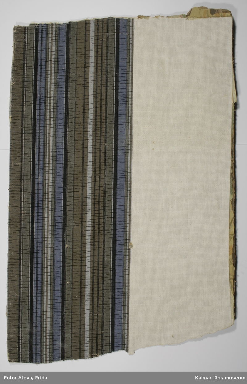 KLM 39925:3:1. Tapet av papper. 8 st tapetbitar. Tryckt tapet med delar där botten är vit, och delar har lodräta streck i brunt, grått, grönt, blått och svart. På någon bit syns en bård, B 3,5 cm, med blå och gröna blad på svart botten och med gulddetaljer. Tapetpappret har en reliefkänsla i form av väv. På flera av bitarna står skrivet: V. Sjögatan 16 och på en står V. Sjögatan 16 N.B mot gatan.