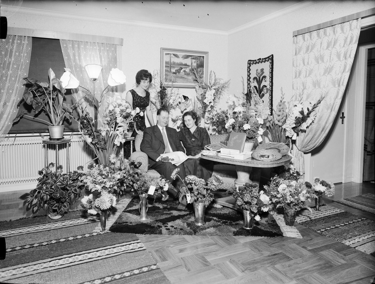 Man, med familj, i hemmiljö omgiven av blommor firar 50-årsdagen, Östhammar, Uppland