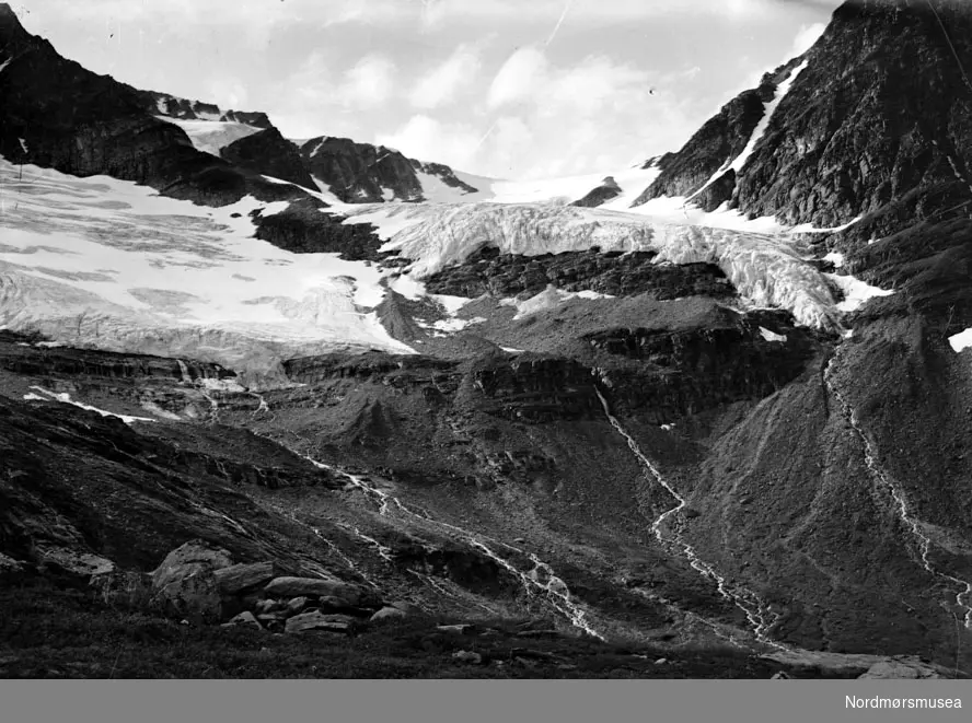Foto fra en liten elv oppe i fjellene. Muligens fra Virumdalen i Sunndal kommune etter påskrift på konvolutt. Datering er ikke kjent, men kan muligens være fra tiden omkring 1930 til 1960. Fra Nordmøre museums fotosamlinger.
