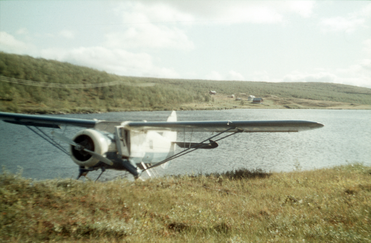 Norseman fra Nor-Wing fortøyd ved bredden av et vann. Antagelig en taxiflyging med fisketurister i Troms eller Finnmark.