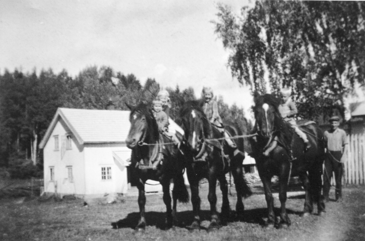 Store Opsahl (79/1). Syver Opsahl med gardens hester. På hesteryggene sitter f.h. Gudbrand, Magnhild, Lars og ?.  Drengestua i bakgrunnen