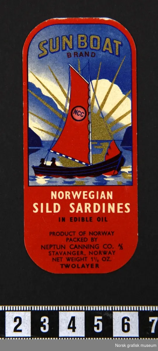 Liten etikett i rødt og blått. Bilde av en seilbåt med en strålende sol i gull i bakgrunnen. 

"Norwegian sild sardines in edible oil"