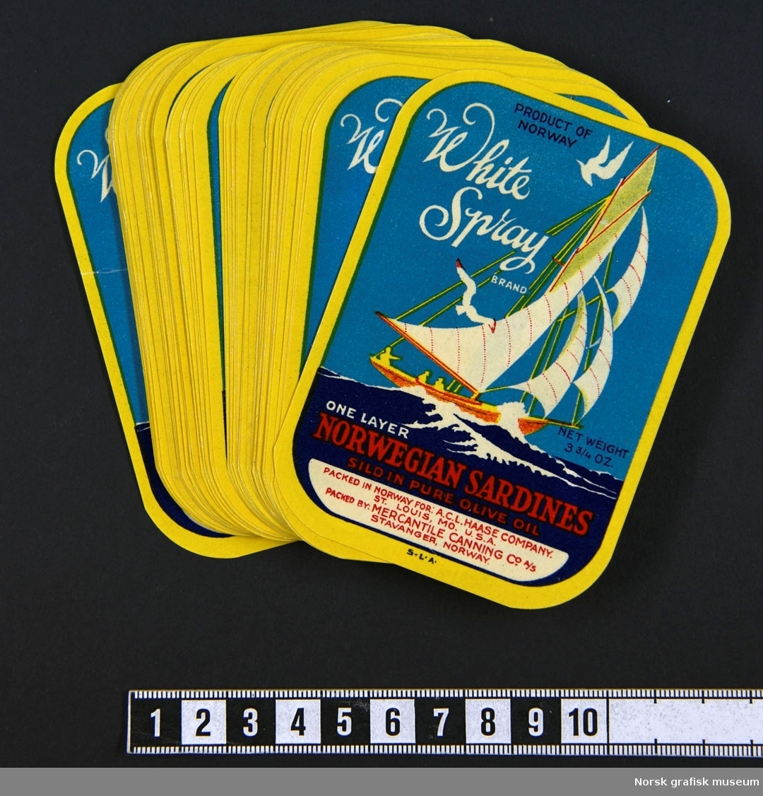 En bunke etiketter med bilde av en seilbåt med fulle seil på havet med hvite topper på bølgene. Vi kan skimte siluetten av mennesker ombord og måker rundt masten. 

"One layer Norwegian sardines sild in pure olive oil"
