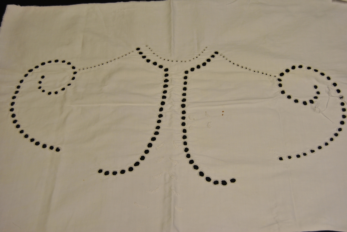 Rektangulært avskåret tøystykke av sengetøy. Brodert med engelsk hullsøm i geometrisk mønster.