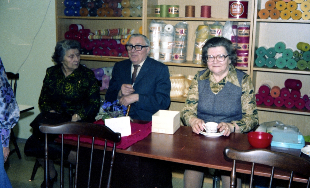 Julförsäljning av hantverk i pensionärernas hobbylokal på Våmmedalsvägen år 1977. Från vänster: 1. Okänd kvinna. 2. Einar. 3. Ester Karlsson (1907 - 2001) som sitter och fikar.