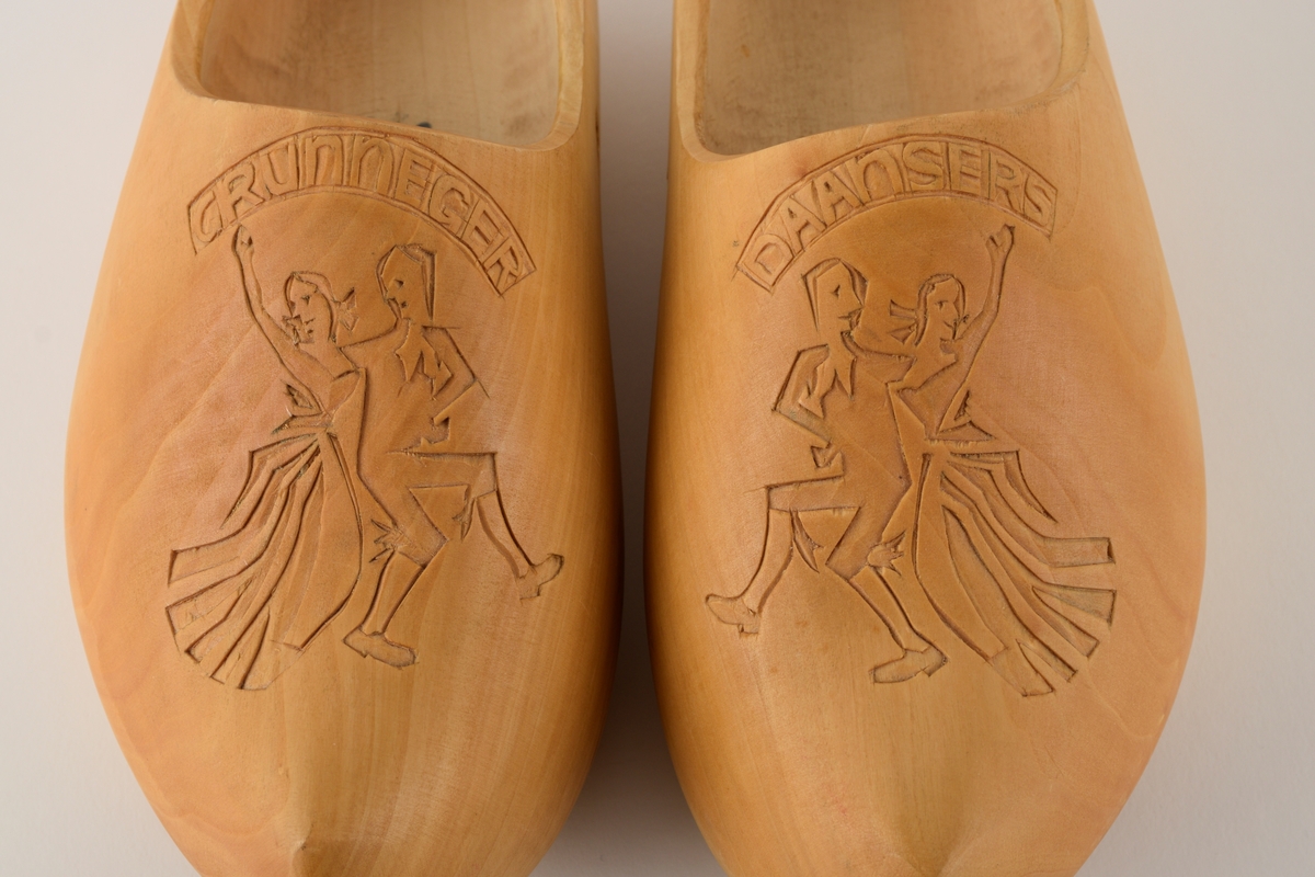 Motiv av et dansende par er skåret inn på begge sko.