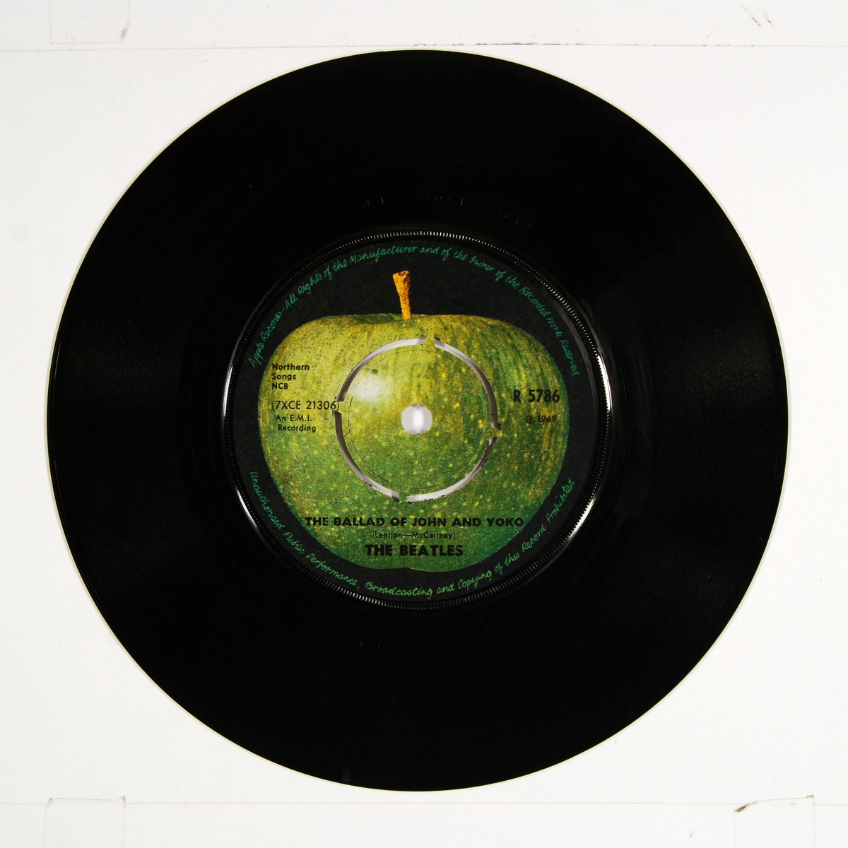 Fotografi av "The Beatles" på coveret. Plateetiketten viser et grønt eple på A-siden og et delt eple på B-siden.