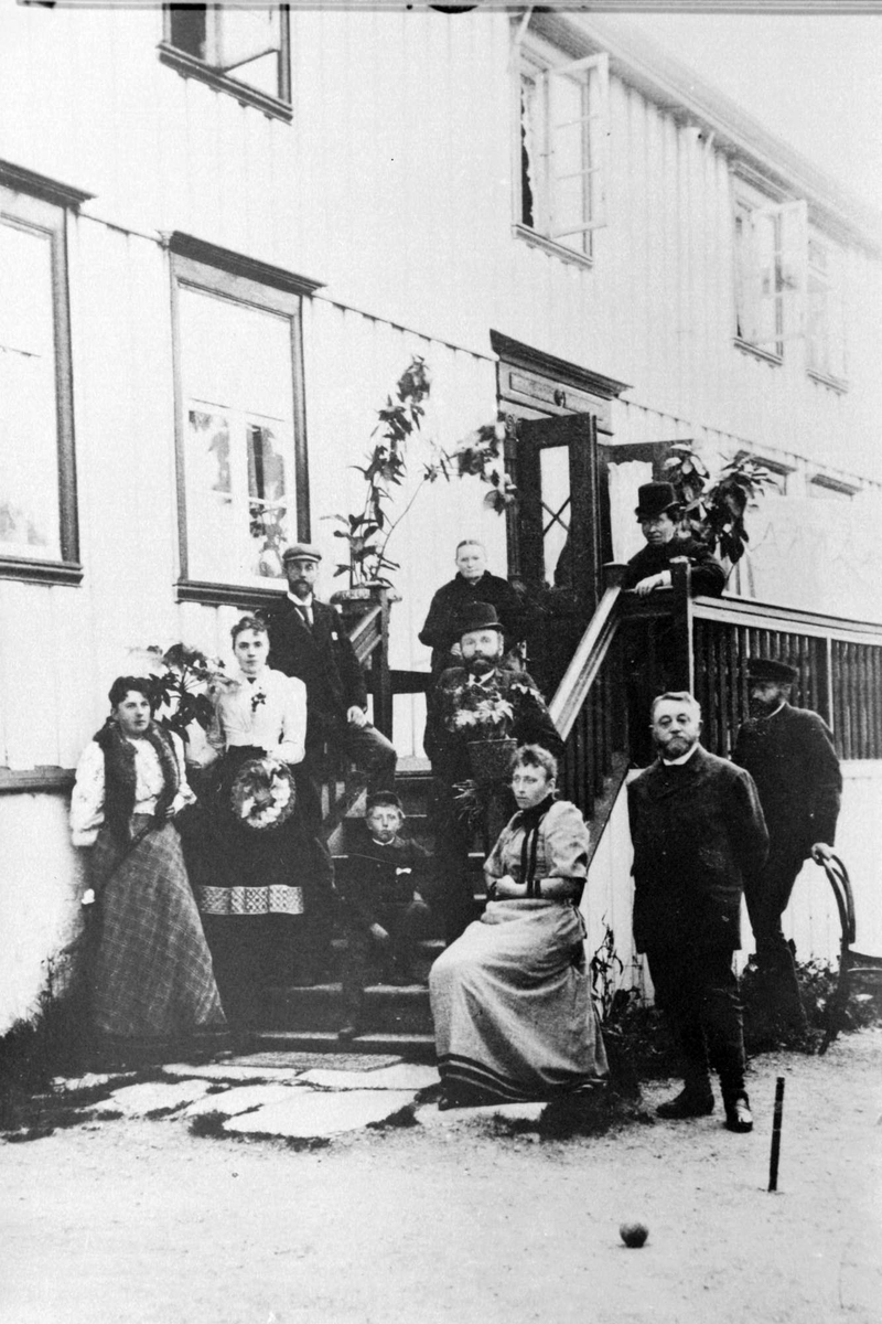 Personer på gårdsplass og på trappen foran Fochsengården.