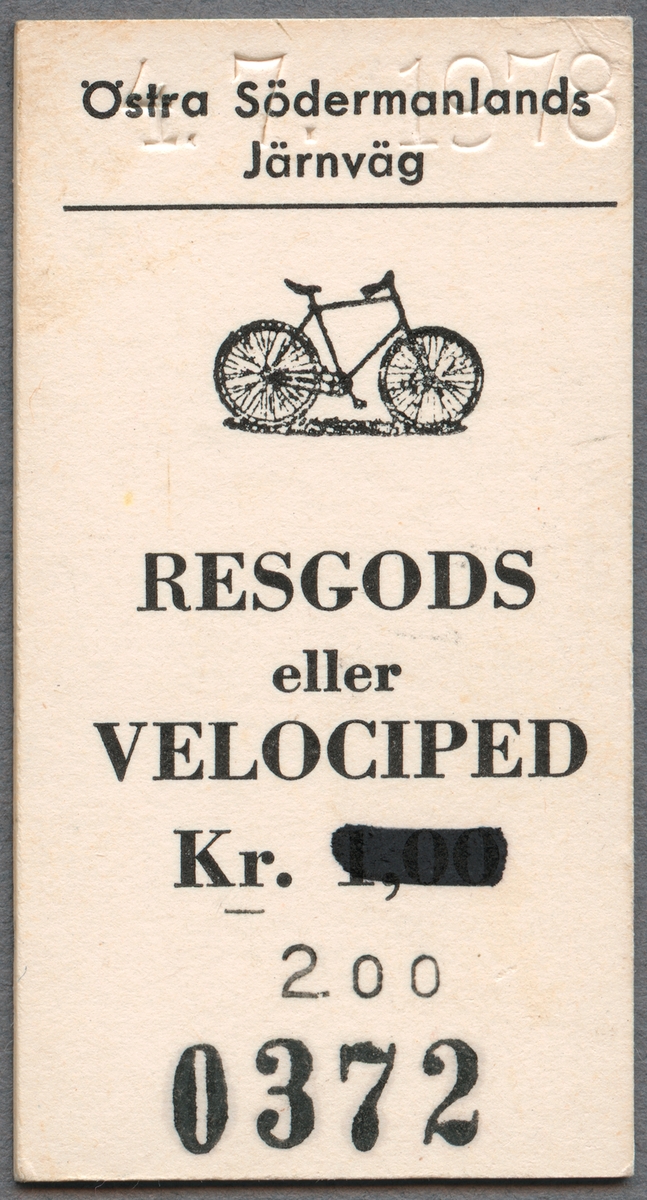 Museitågbiljett för Östra Södermanlands Järnväg för resgods eller velociped. Biljetten är av vit papp i Edmondsonskt format och har en bild av en cykel. Biljetten har ett präglat datum i toppen. Biljettens pris var 2 kronor. Ett tidigare pris på 1 krona är övermålat.