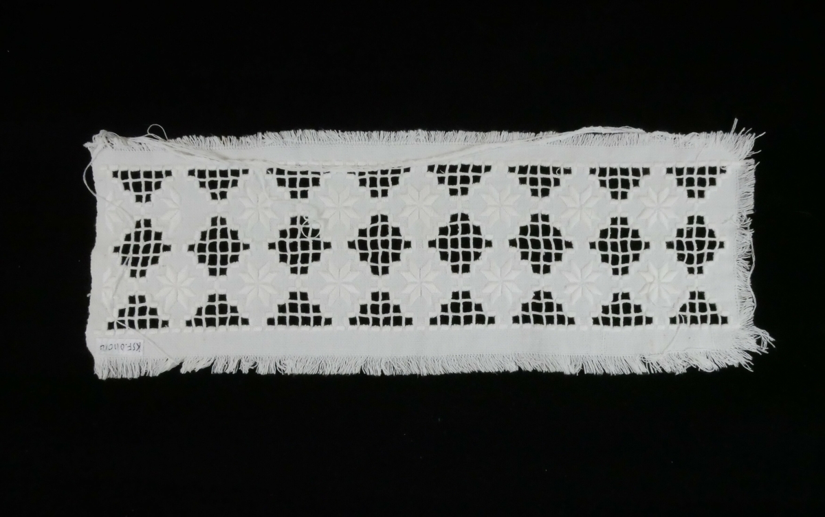 Rektangulær hvit tekstil med uferdig broderi i hardangersøm