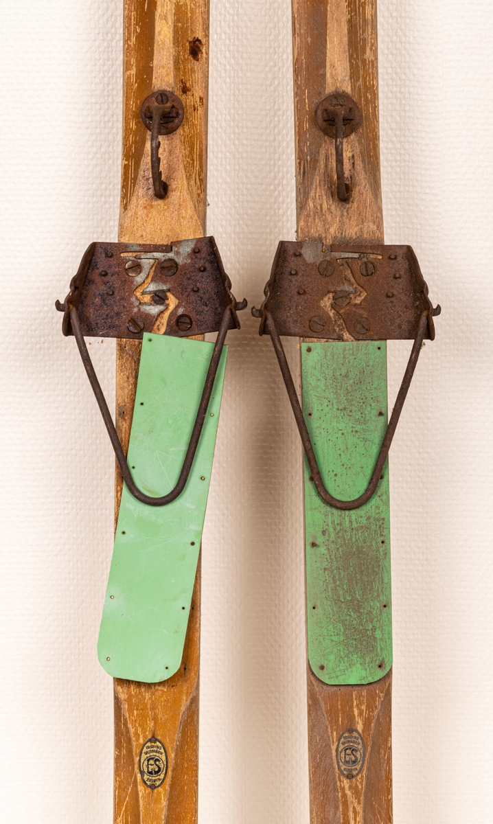 Ett par träskidor med bindningar i metall (rostiga). Märke påklistat med "Edsbyns Skidfabrik".