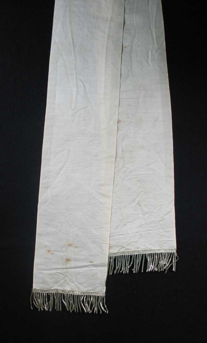 Begravelsessløyfe i hvit silke med sølvfrynser. Ingen tekst.