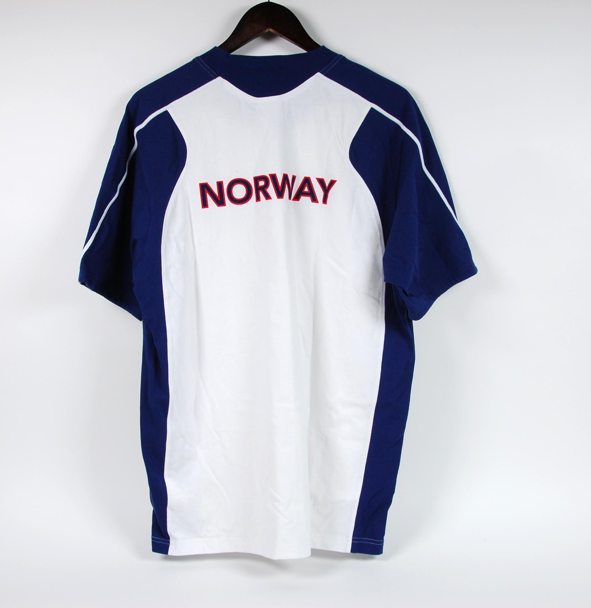 Hvit og blå t-skjorte med laminert logo for Adidas, laminert norsk flagg og signaturen til Olaf K. Tufte.