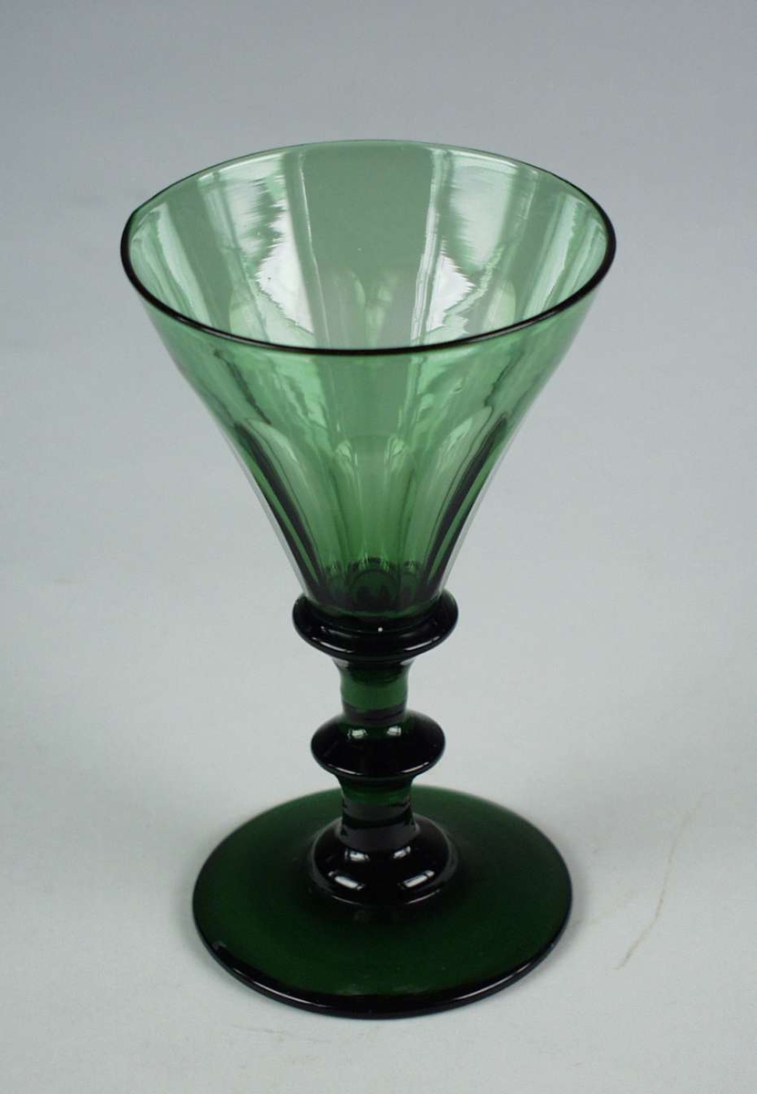 Olivengrønt vinglass med spiss, fasettslipt klokke og skive i stetten.