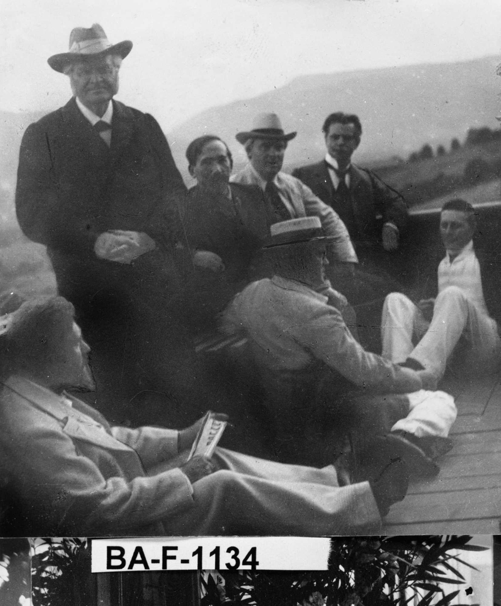 Fotomontasje i svart/hvitt rammet inn med glass og enkel trelist. Amatørbilder.