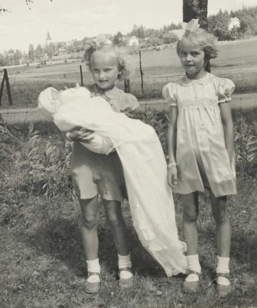 Stolte søstre med lillebror som dåpsbarn i 1947