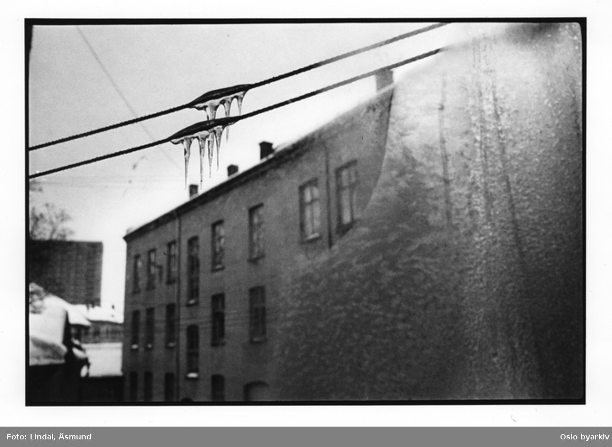 Utsikt mot bakgården om vinteren. Is i vinduet, istapper på klessnora. Fotografiet er fra prosjektet og boka ''Oslo-bilder. En fotografisk dokumentasjon av bo og leveforhold i 1981 - 82''. Kontakt Samfoto ved ev. bestilling av kopier.
