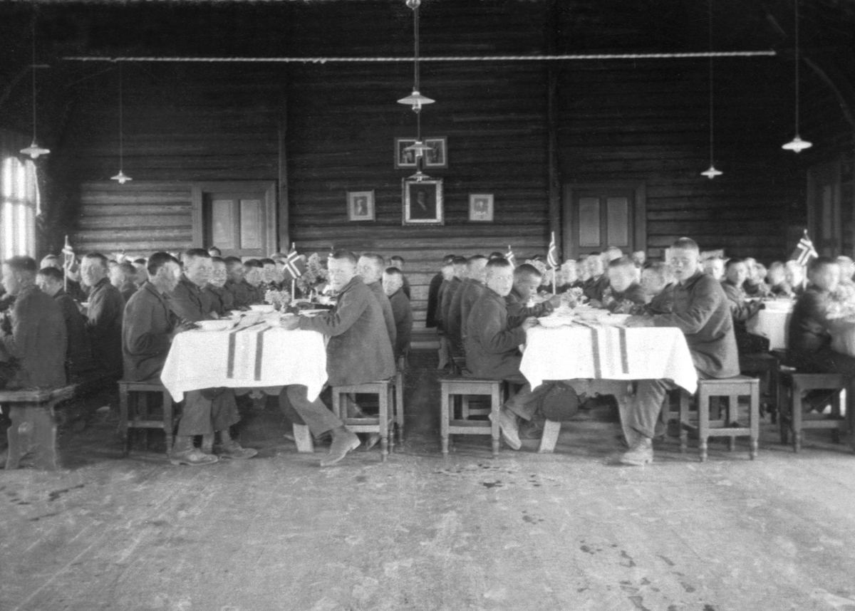 Interiør fra matsalen på Toftes Gave, Nedre Sund, Helgøya. Gutter ved dekkede bord pyntet med flagg.