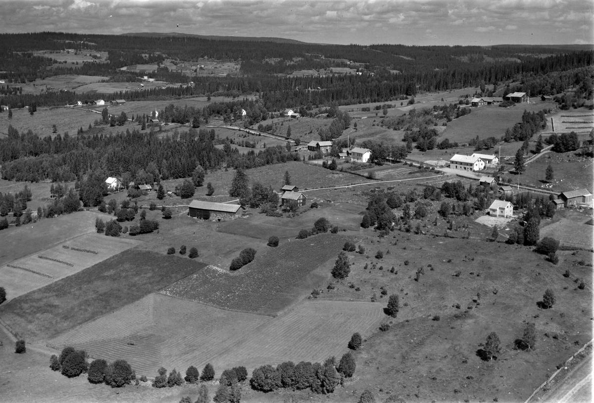 Flyfoto av Kauserud gard sentralt i bildet, man ser også gamleskolen i Åsmarka med Åsheim forsamlingslokale rett ved siden av.