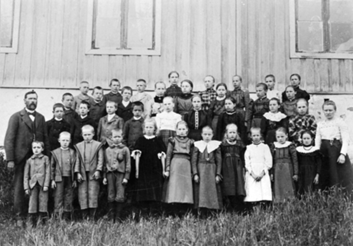 GRUPPE: 38 SKOLEELEVER, SKOLEKLASSER, VARDEBERG SKOLE, VARDEBERG KRETSSKOLE, TANGEN, 
gutt nr 3 i 2. rekke ved siden av læreren, er Karl Ludvik Alnæs? født i 1892. 