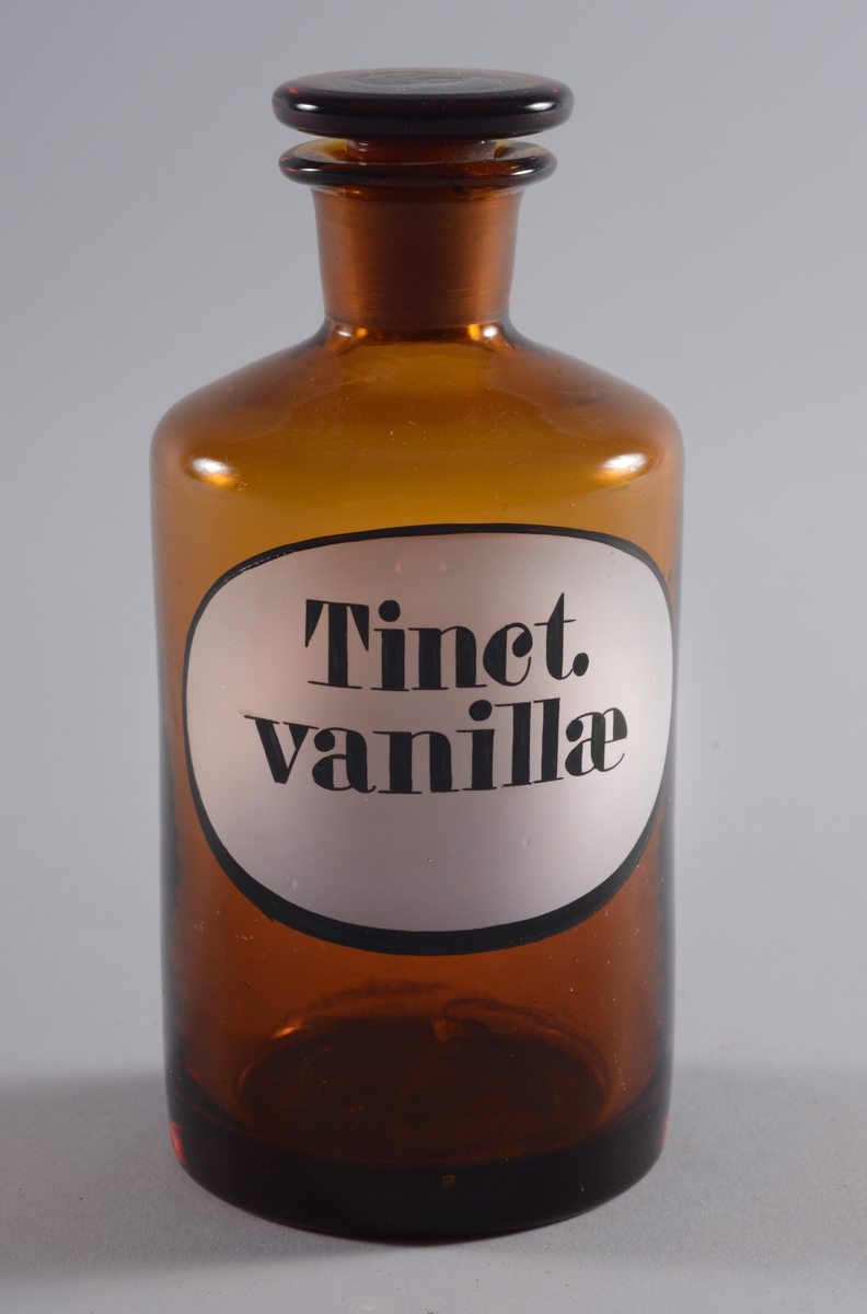 Flaske
Brunt glass med slepen,flat propp.
Oval etikett med svart skrift.
 