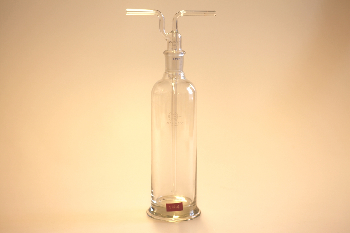 Flaske (A) med rett mage. Korken (B) har to åpningen i form av slanke rør. Beholder som sprer gass i bobler for større effektivitet.