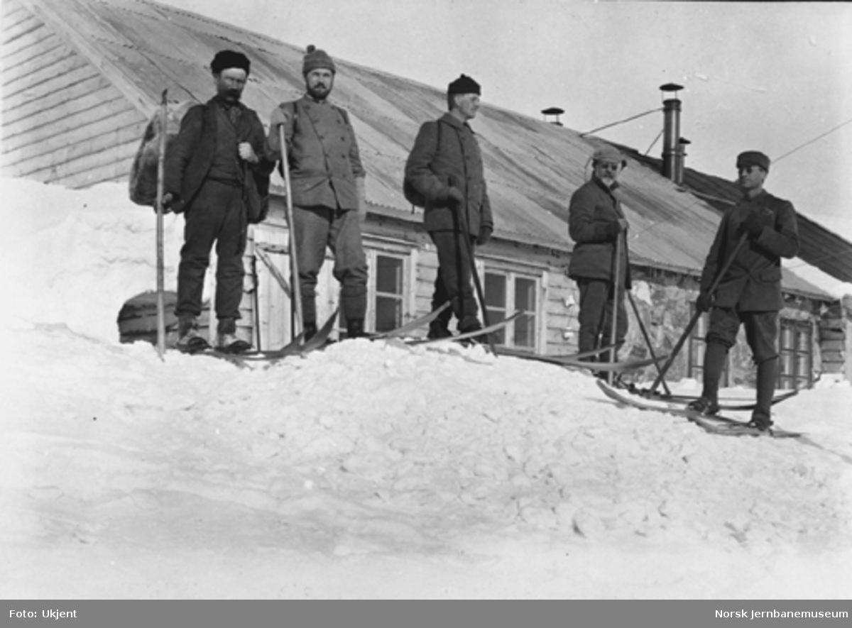 Bergensbanens anlegg; fem menn på ski foran ingeniørboligen på Hallingskeid