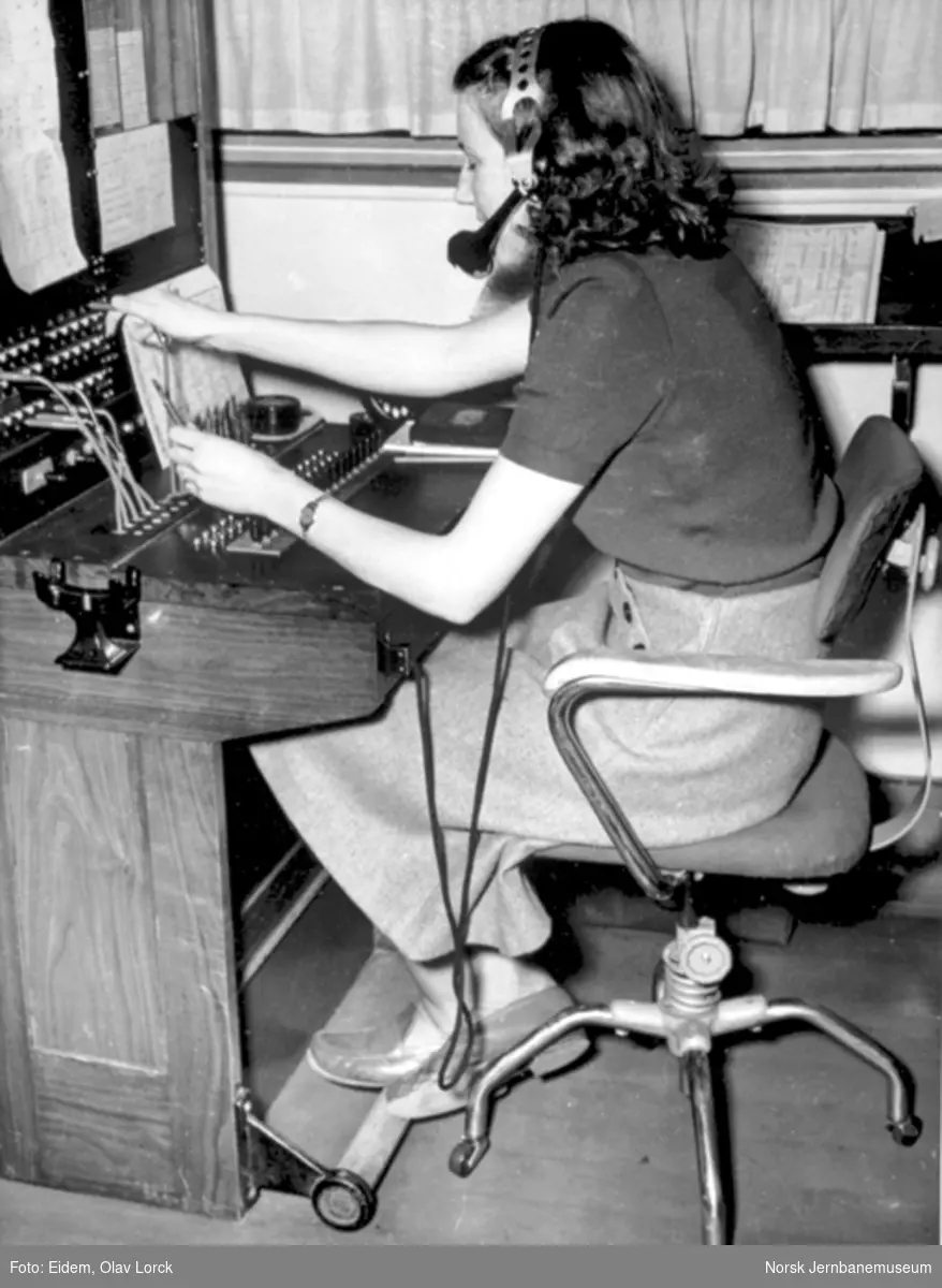 En dame betjener telefonsentralen på NSBs reisebyrå i Oslo