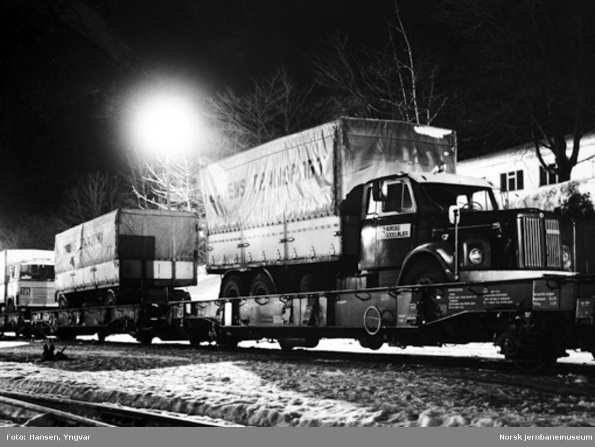 Lastebiler og tilhengere opplastet på dyplastevogner på Åndalsnes stasjon
