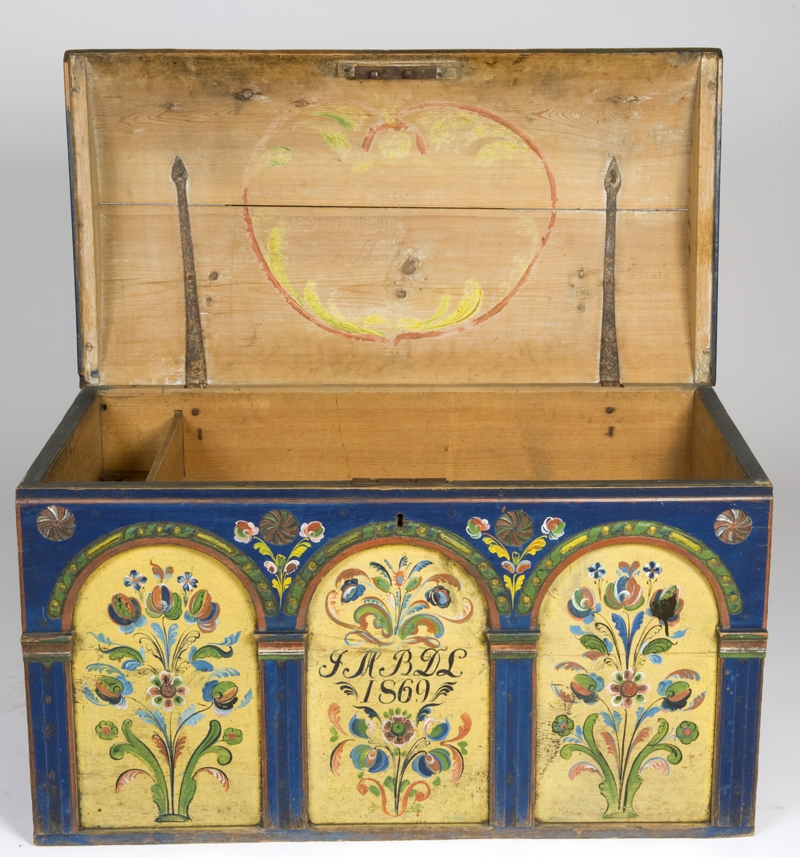 Kiste med buet lokk og rosemalt. På forsiden tre arkader, kortside ådret.