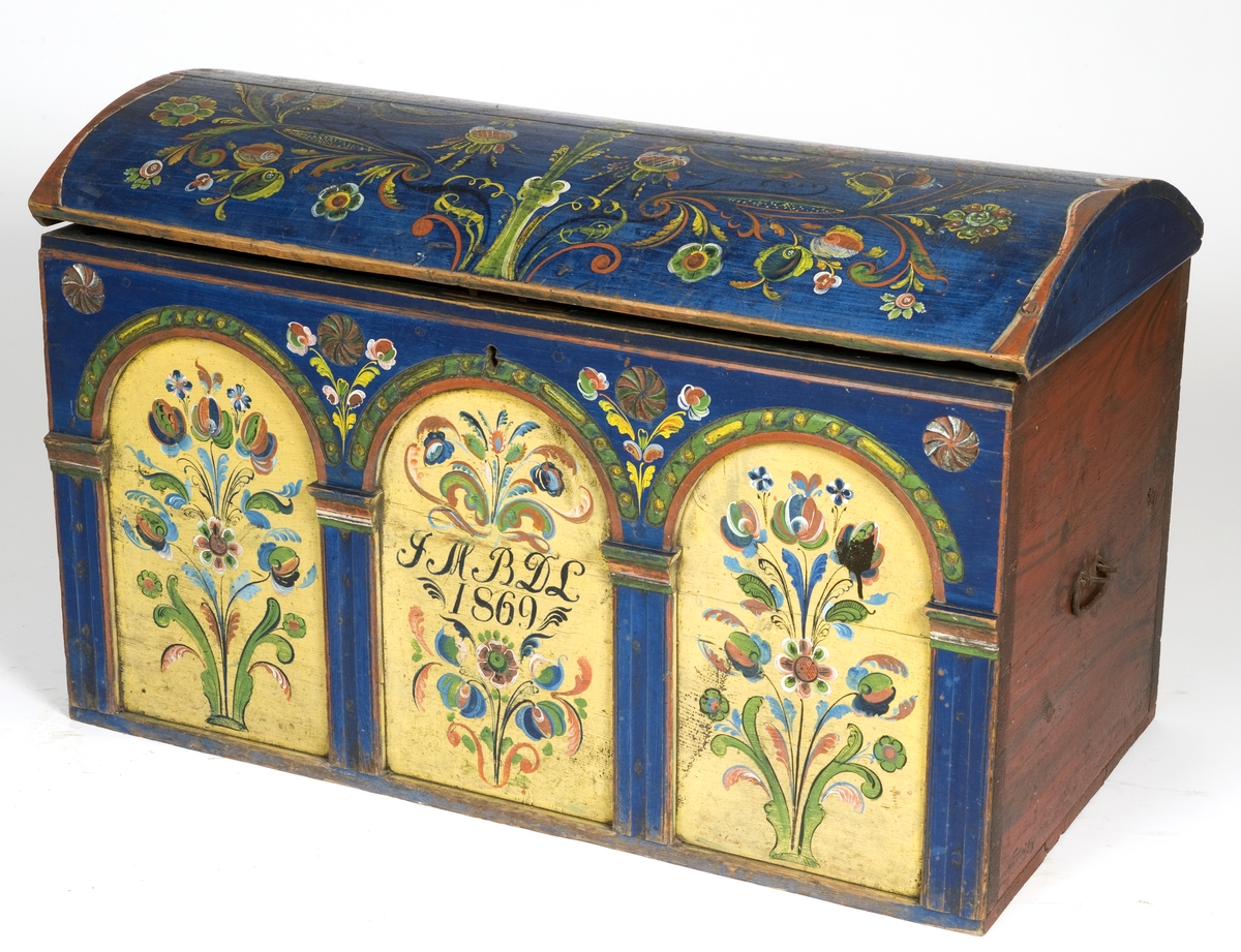 Kiste med buet lokk og rosemalt. På forsiden tre arkader, kortside ådret.