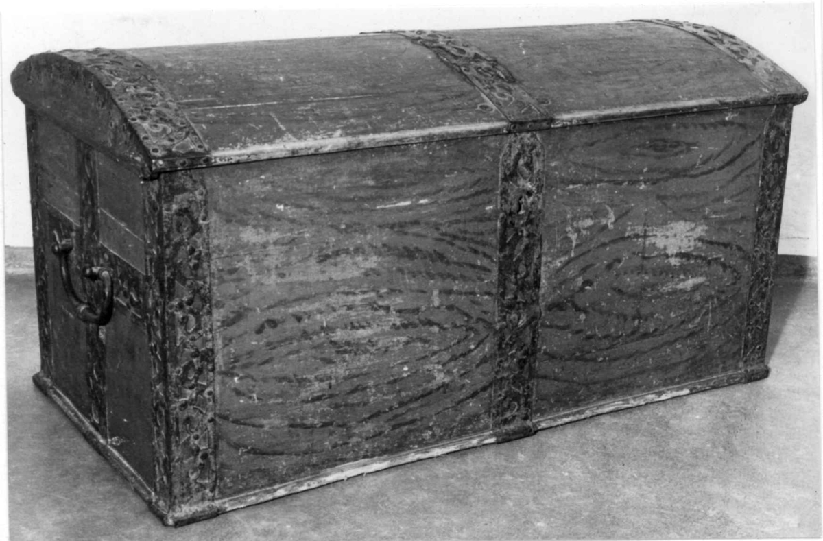 Kiste med buet lokk og gjennombrudte jernbeslag og bånd. Utvendig ådret og med initialer og årstall på baksiden. Innvendig bemalt med to engler og små hus i lokket.