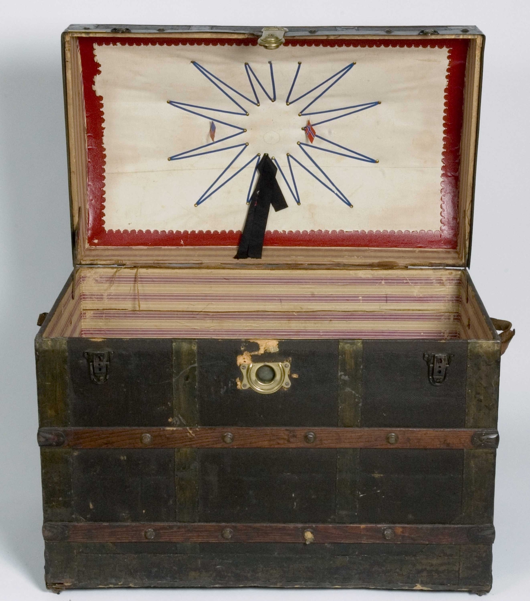 Koffert i kisteform med buet lokk, beslått med jernblikk og trelister. Innvendig utkledd med papir og tekstil.