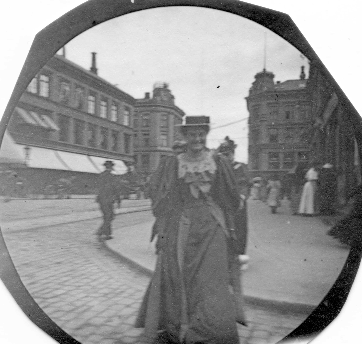 Frk.Heiberg spaserer langs Karl Johans gate, Oslo, med Egertorvet i ryggen.