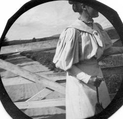 Frk. Solveig Berg ved grind over vei.