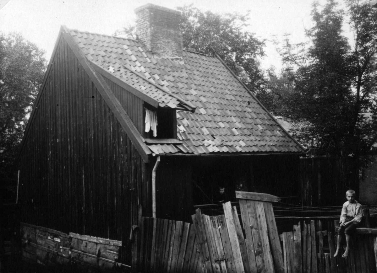 Vinkelgaten 18, Oslo 1921. Trehus med gjerde, Gutt sitter på gjerdet. Pipervika.