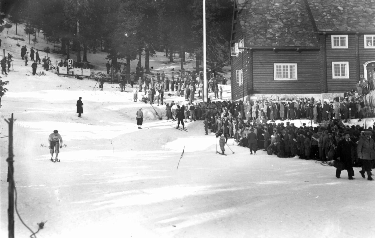 Skirenn i Holmenkollen i Oslo i 1934. Ved innkomsten av 50 km løypa ved Frognerseteren, antakelig. Publikum langs løypa.